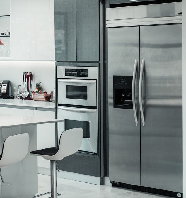 frigider si cuptor din aluminiu otel stainless steel in bucatarie moderna cu masa eleganta si scaune albe